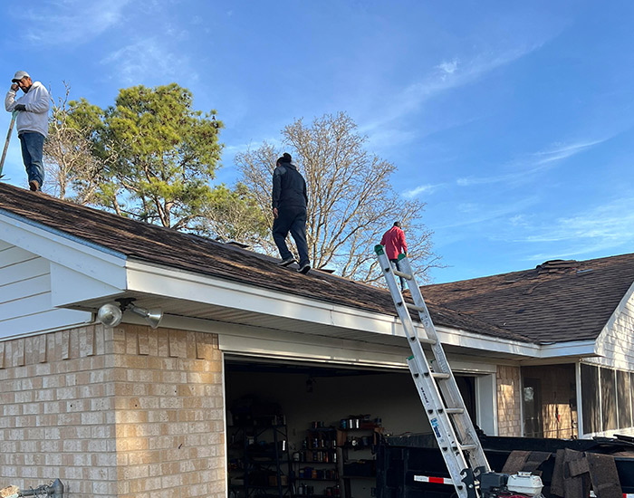 composition roofing contractor repairing roof of a house